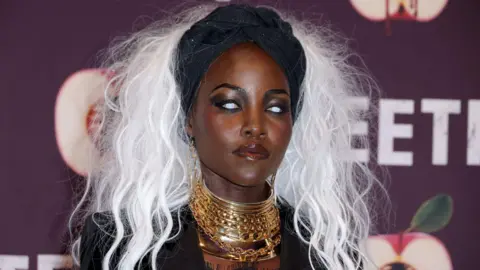 Getty Images Lupita Nyong'o wearing a bright white wig and white contact lenses.