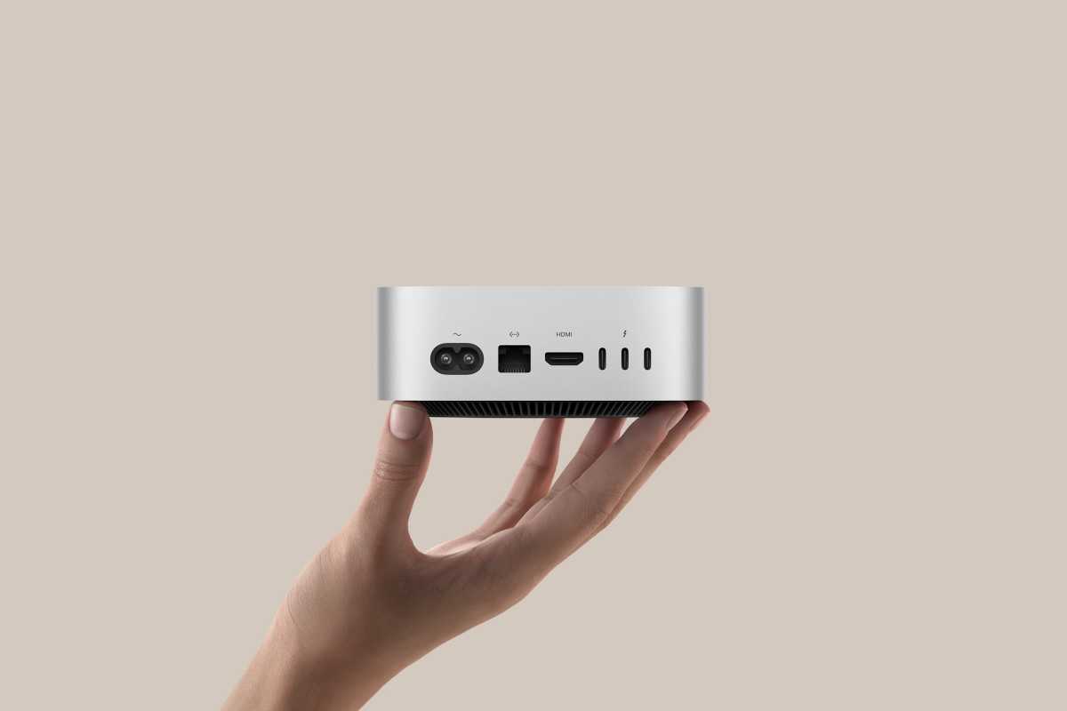 A hand holding the back of the M4 Mac mini showing the ports